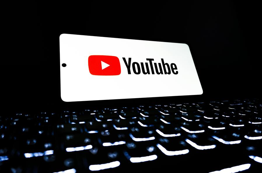 YouTube logo with glowing computer keys underneath.